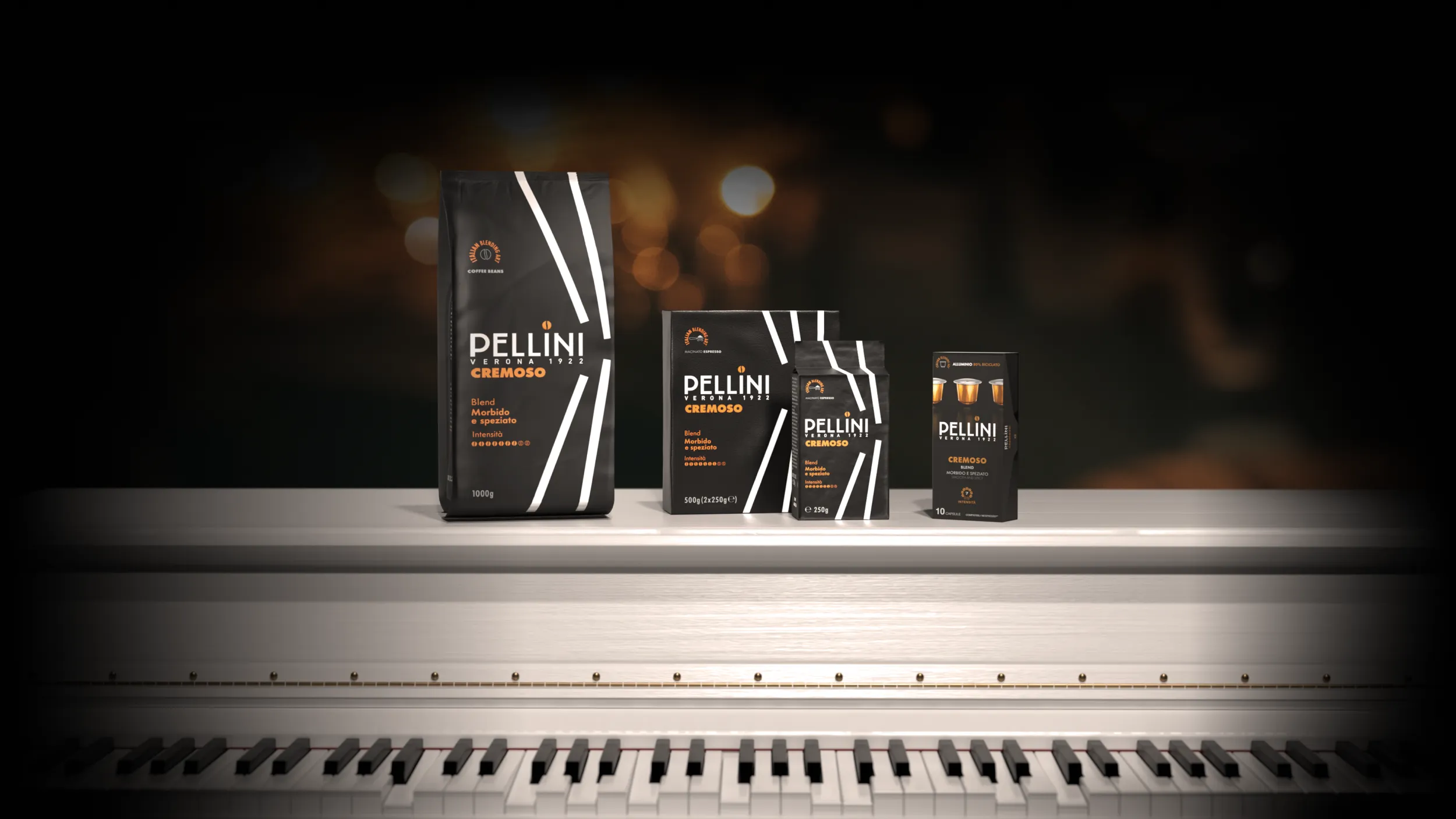 Miscela Cremoso Confezioni di caffè Pellini miscela Cremoso nei formati in grani, macinato espresso e capsule, disposti su un pianoforte